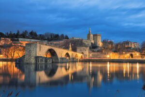 Old bridge and city skyline at dusk in Avignon, France